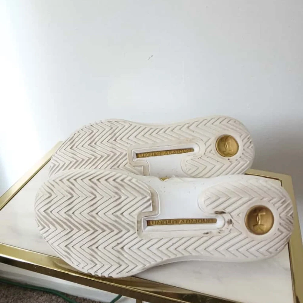 Under Armour White Sneakers with Gold Accents Size 10.